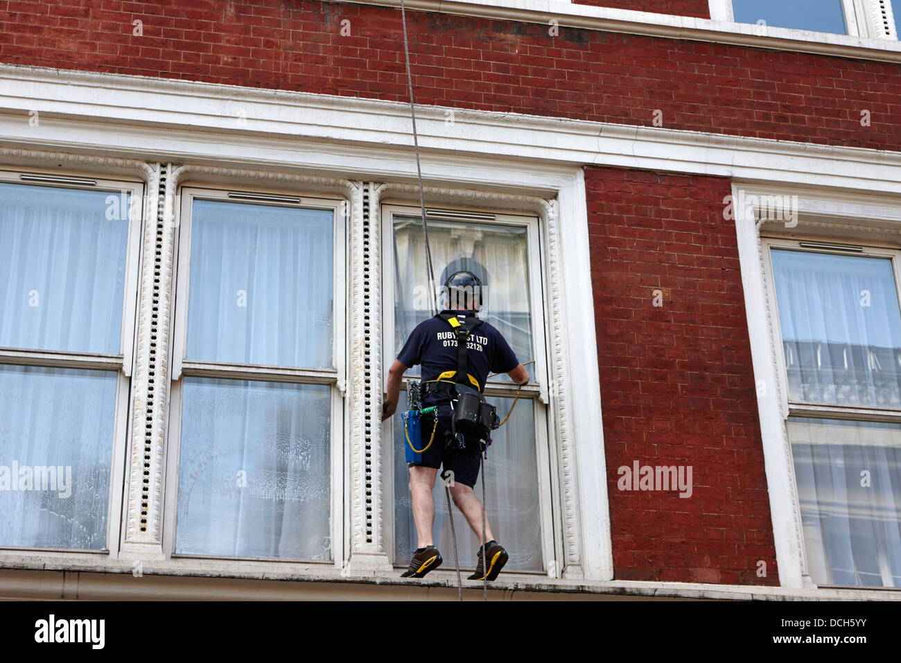 Fenster-Reiniger mit Abseilen Seil London England UK Stockfoto