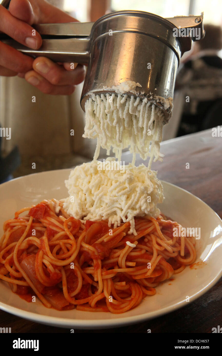 Zubereitung von Spaghetti und marinara Soße hinzufügen den Parmesan-Käse Stockfoto