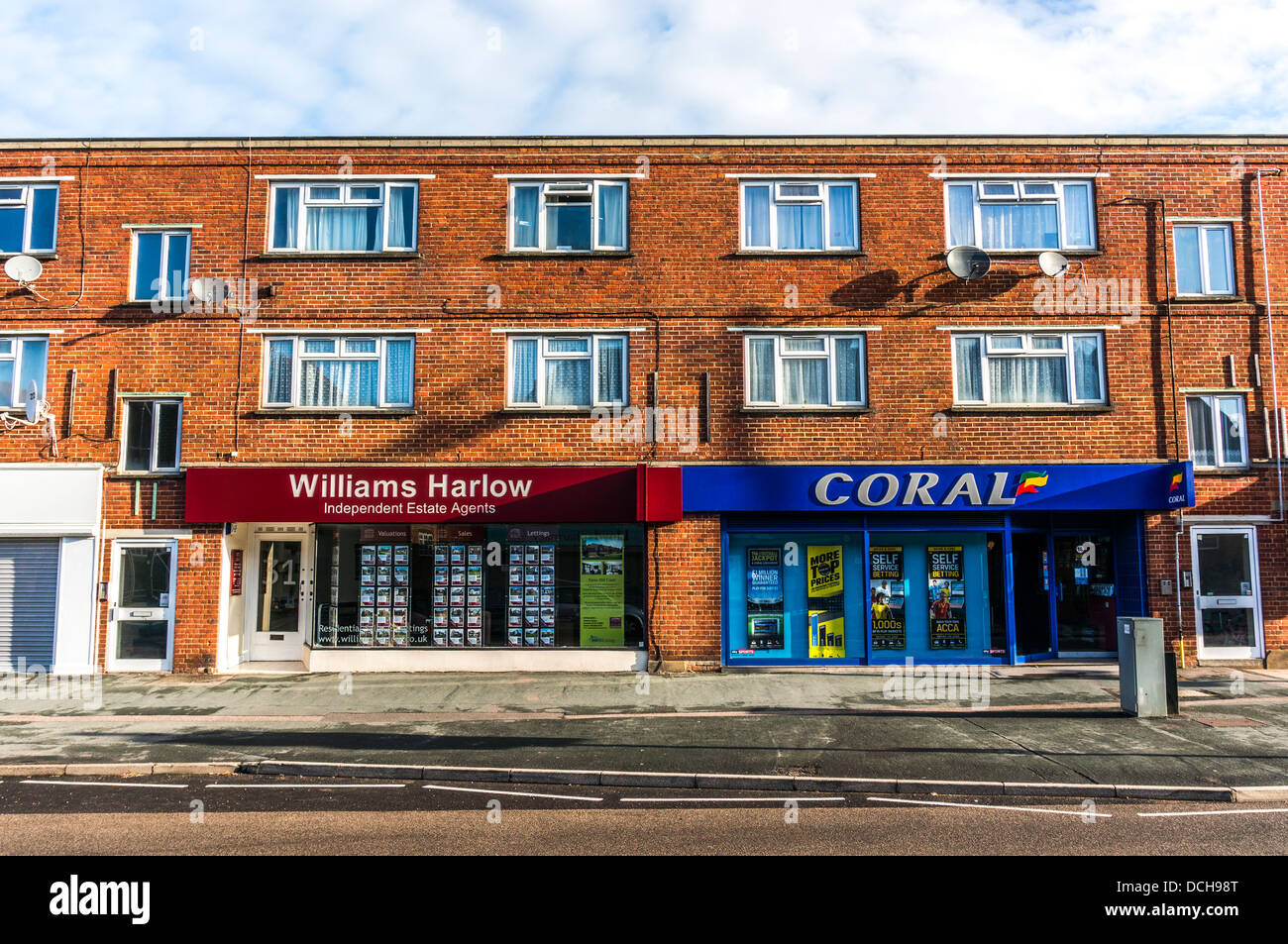 Williams Harlow Immobilienmakler und Korallen Buchmacher auf Banstead Dorf High Street, in einer ruhigen Sonntagmorgen in Surrey, England. Stockfoto