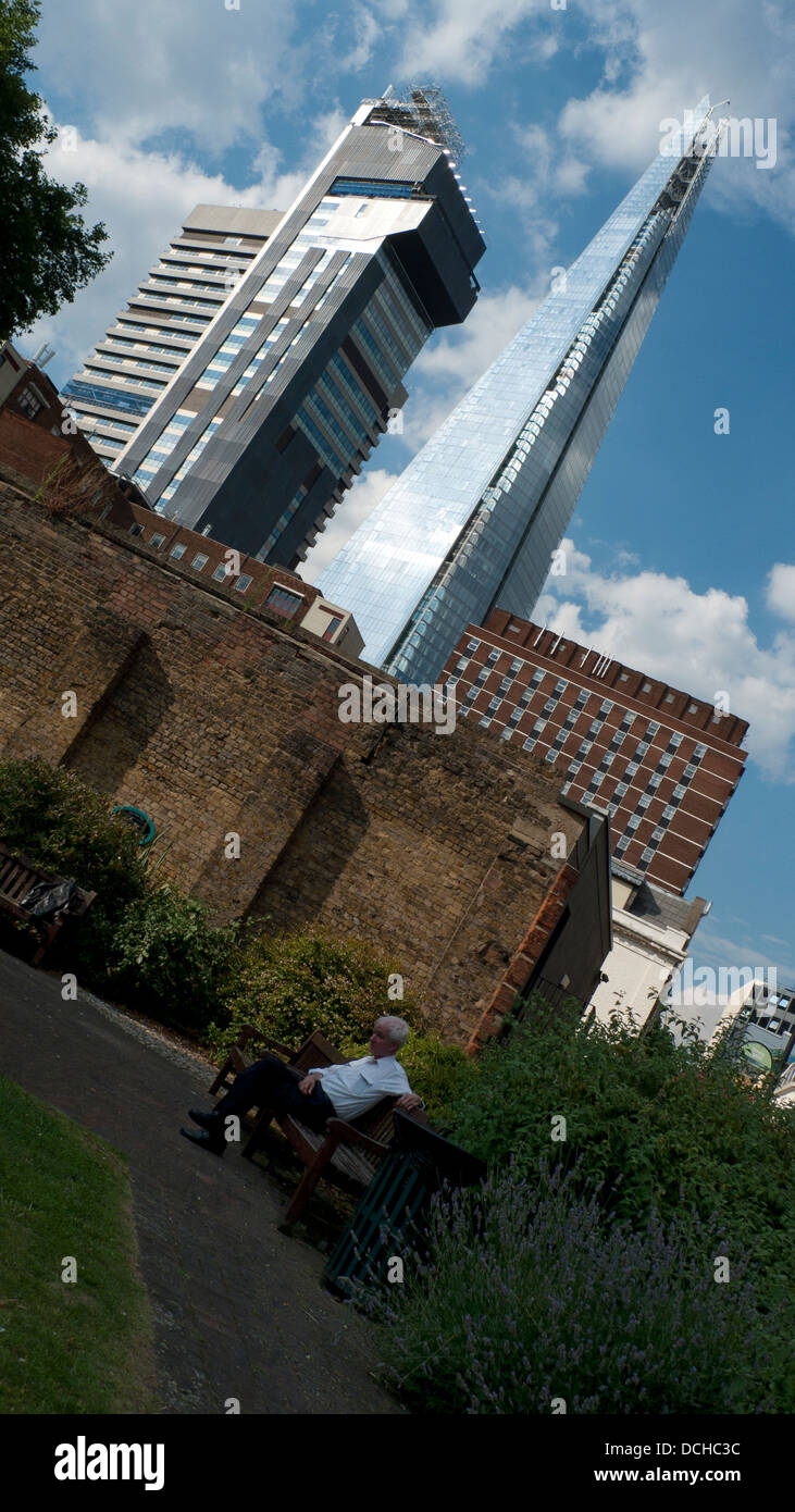 Älterer Mann sitzt auf einer Parkbank mit Shard Gebäude in der Ferne South London England UK Stockfoto