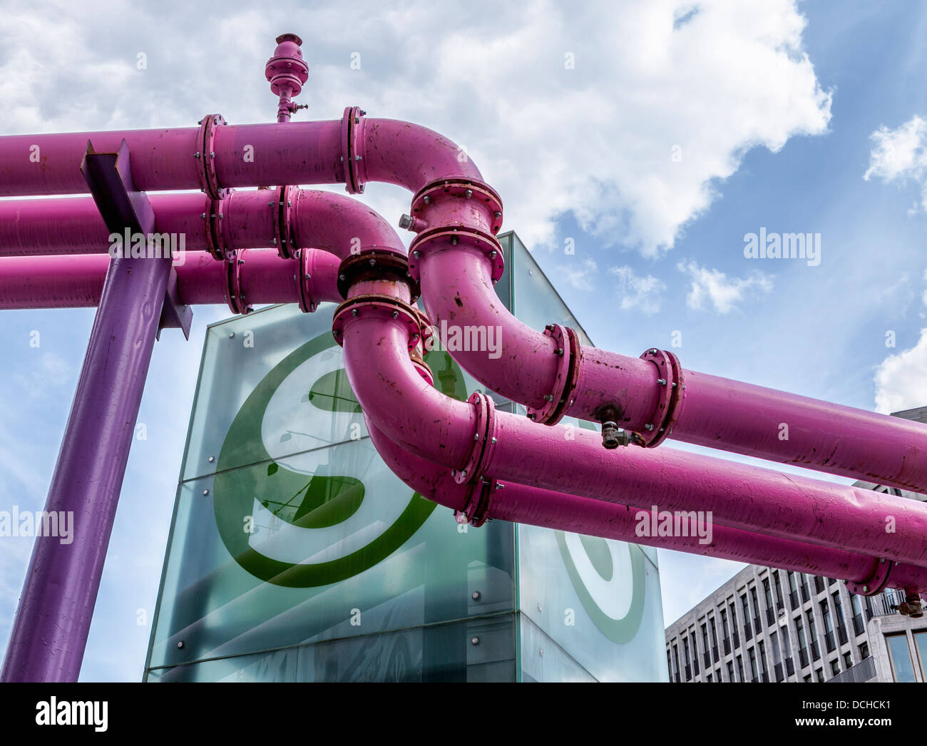 Die rosafarbenen Wasserabflussrohre, die Grundwasser von Baustellen und S-Bahn-Station ableiten, stehen gegen einen trüben blauen Himmel - Berlin Stockfoto