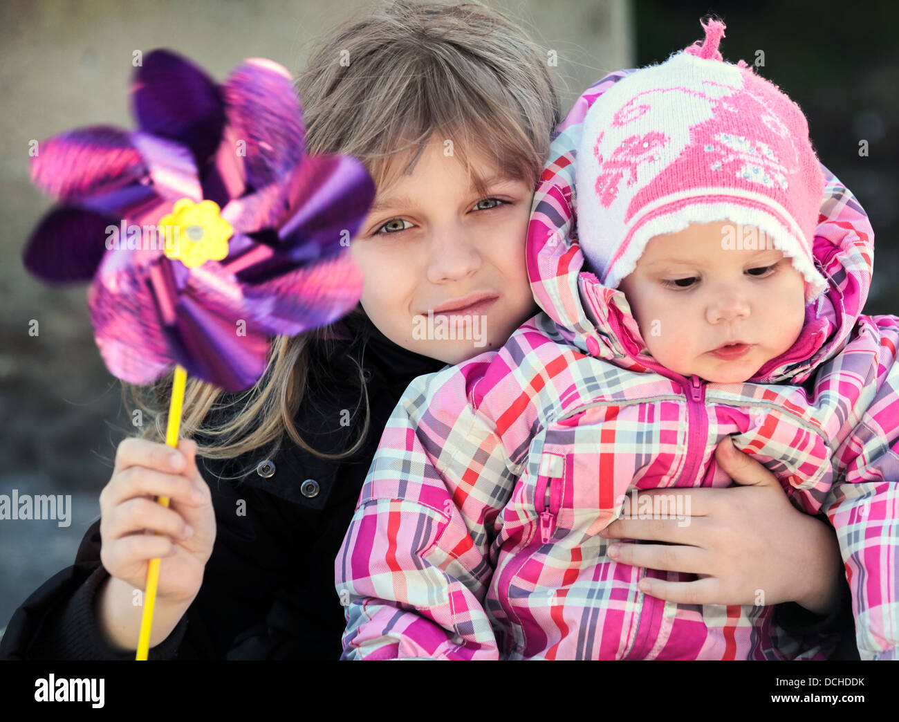 Zwei kleine Schwestern outdoor Portrait mit Windrad Spielzeug Stockfoto