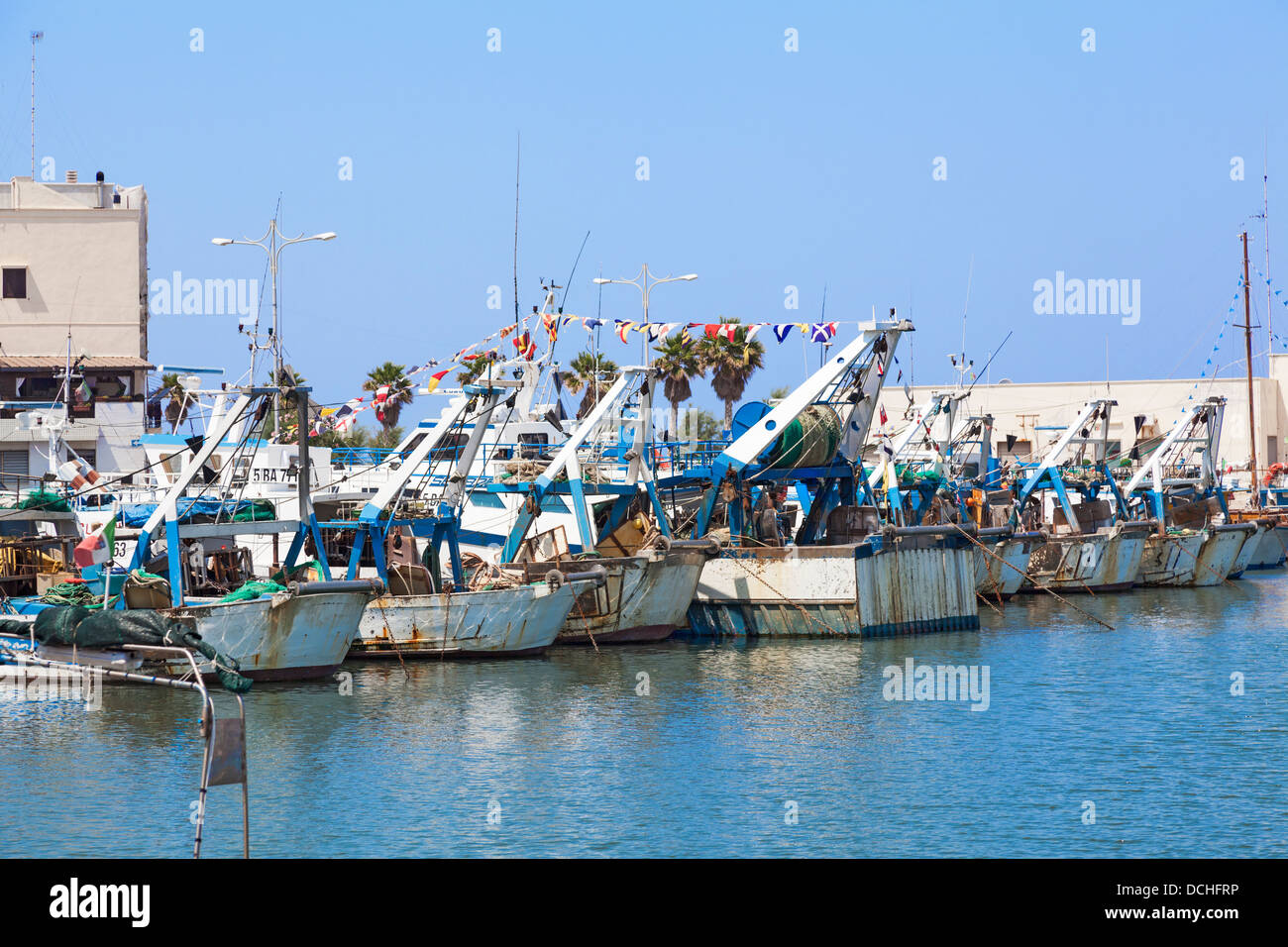 Italienische Angelboote/Fischerboote vertäut im Hafen von Mola di Bari in Apulien, Süditalien unter einem strahlend blauen Himmel Stockfoto