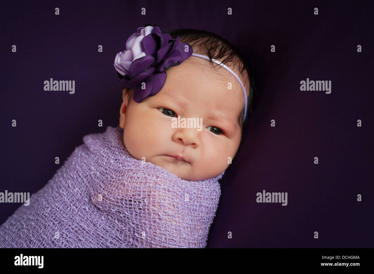 Neugeborenes Babymädchen in lila und Lavendel Stockfoto