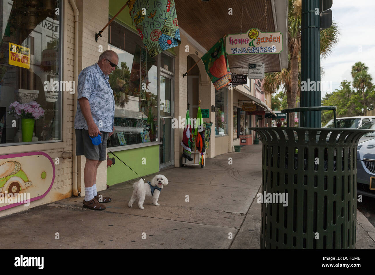 Ein Mann zu Fuß ein Französisch Pudel auf dem Bürgersteig Stadt von Mount Dora, Florida USA Stockfoto
