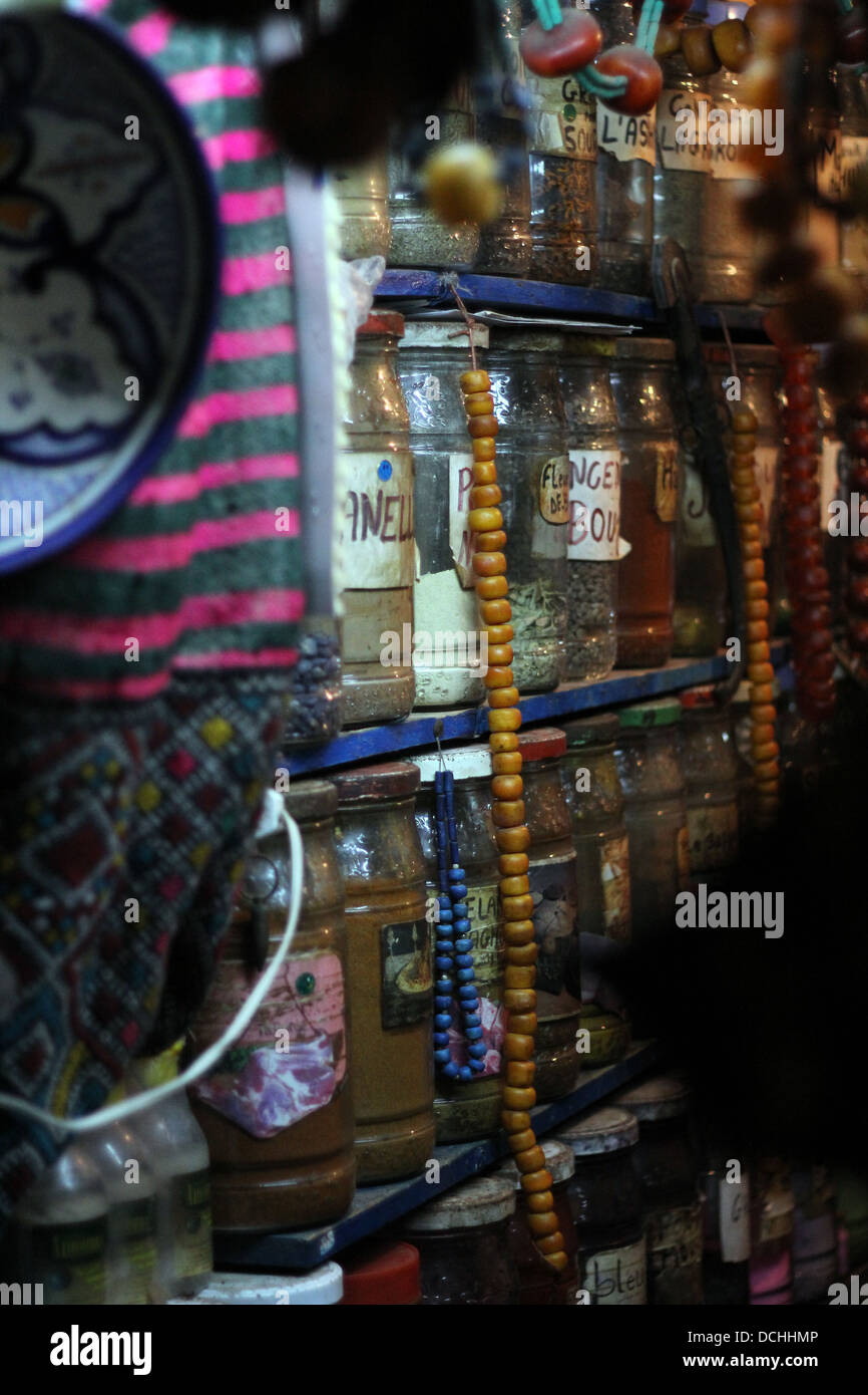 ein Apotheker, gesäumt von Gläsern der Gewürze und Heilkräuter in Essaouira, Marokko. Stockfoto