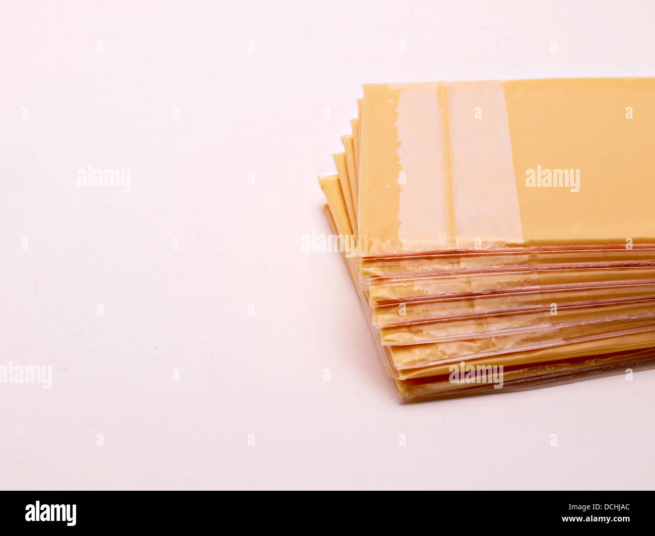 Ein Stapel von amerikanischer Käsescheiben legt auf einem weißen Hintergrund. Stockfoto