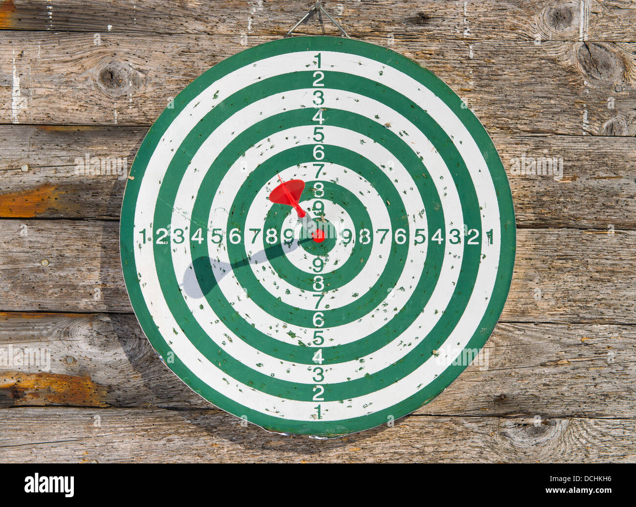 Roter Pfeil Treffer ins Schwarze des Dartboards Stockfoto
