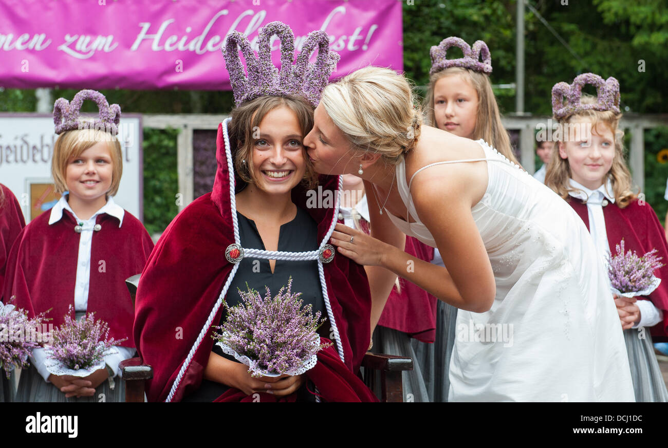 Amelinghausen, Deutschland. 18. August 2013. 19-Year-Old Lara-Sophie Sebastian bekommt einen Kuss von ihrem Vorgänger Jana George nach ihrer Wahl als die neue Heather Queen in Amelinghausen, Deutschland, 18. August 2013. Die Wahl ist der Höhepunkt des jährlichen "Heidebluetenfest" (lit.) "Heather Blumenfest"). Nach der Krönung beginnt der traditionelle Umzug mit geschmückten Wagen Festival, Musikgruppen und Predestrians. Foto: PHILIPP SCHULZE/Dpa/Alamy Live News Stockfoto