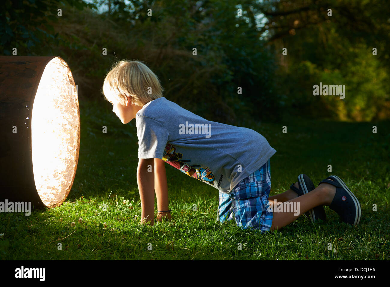 Kind junge finden Sie einen Schatz in magische Fass in der Dämmerung - Suche in tunnel Stockfoto
