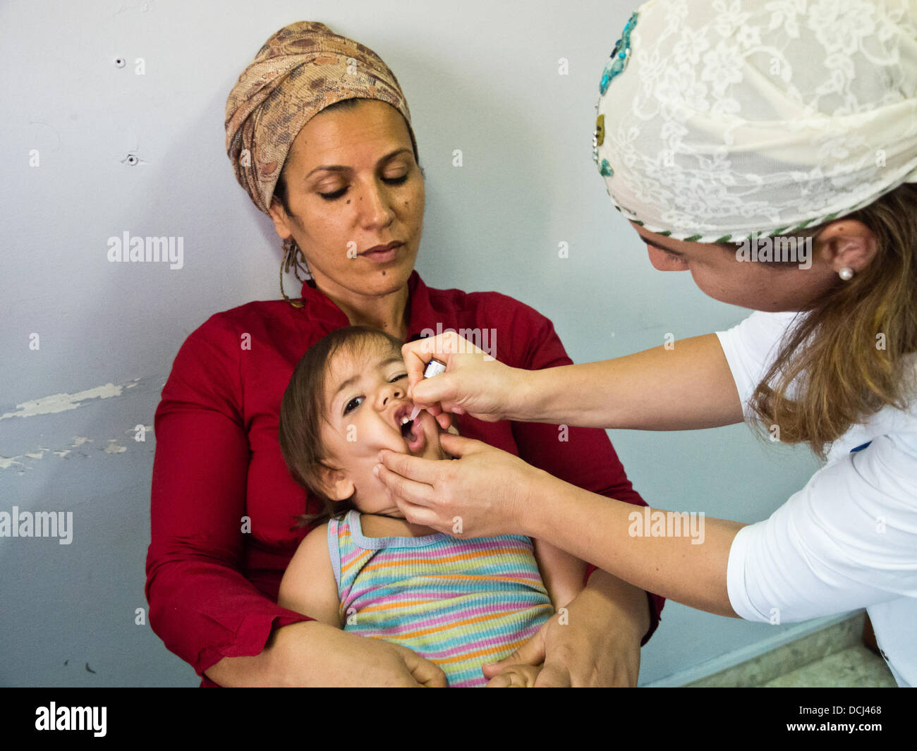 Jerusalem, Israel. 19. August 2013. Ein junges Kind erhält mündlich zwei Tropfen des geschwächten Polio-Virus der Stämme 1 und 3 im Gesundheitszentrum Nachbarschaft. Jerusalem, Israel. 19. August 2013. Israel startet eine bundesweite Kampagne zur Inokulation von 1 Million Kinder gegen Polio, das Virus im Abwasser im Süden gefunden zu steigern. Zwar gab es keine klinischen Fälle des Virus, haben einige Kindertragen identifiziert worden. Bildnachweis: Nir Alon/Alamy Live-Nachrichten Stockfoto