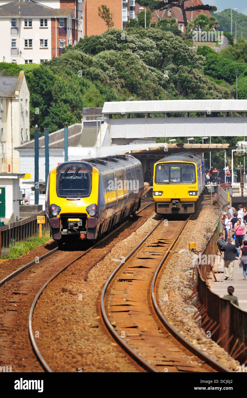 Ein Crosscountry express Personenzug übergibt ein First Great Western regional Nahverkehrszug in Dawlish Station in Devon Stockfoto