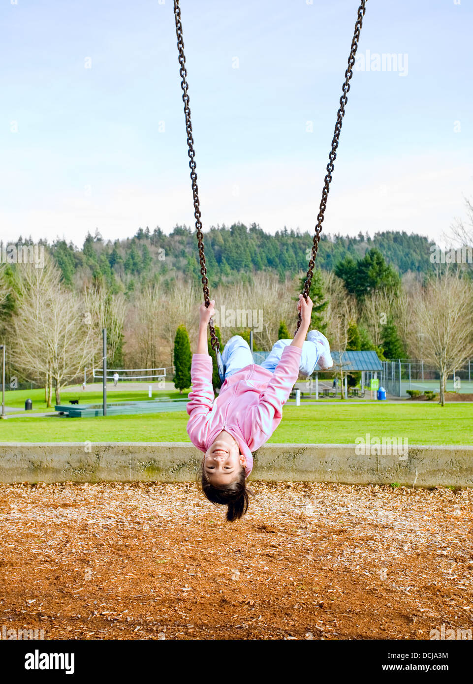 Glücklich neunjährige Teil asiatische Mädchen auf der Schaukel im park Stockfoto