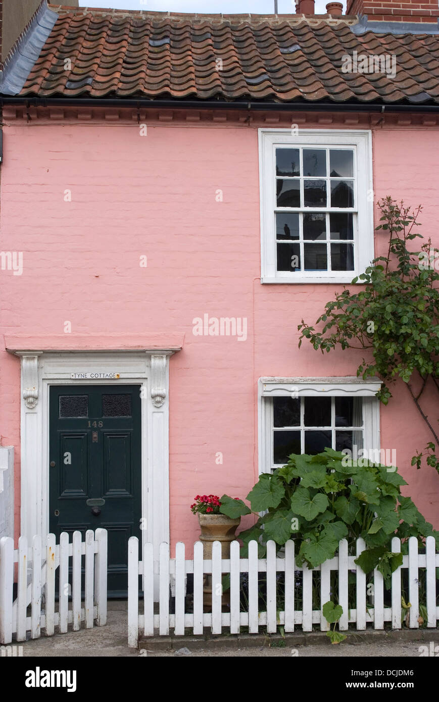 Zweigeschossige rosa gestrichenen Häuschen mit weißen Lattenzaun, Aldeburgh, Suffolk, England Stockfoto