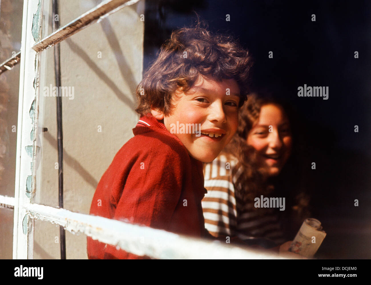 Glücklicher englischer Junge und seine Tante lächeln durch ein Fenster Norwich Norfolk UK in England Großbritannien in den 1970er Jahren 1973, 1974 KATHY DEWITT Stockfoto