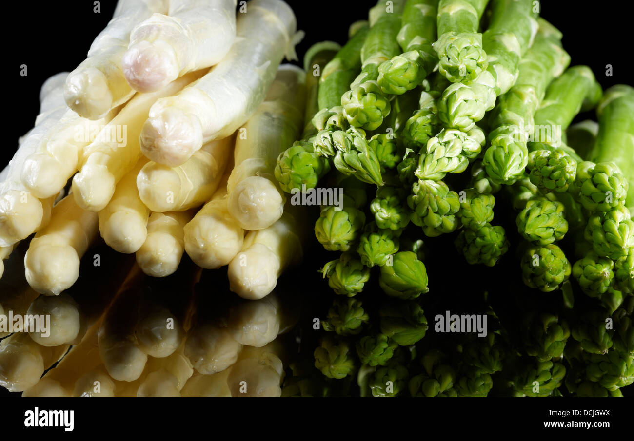 Trauben von weißem und grünem Spargel Gemüse in Schwarz Reflektierende Rückseite Stockfoto