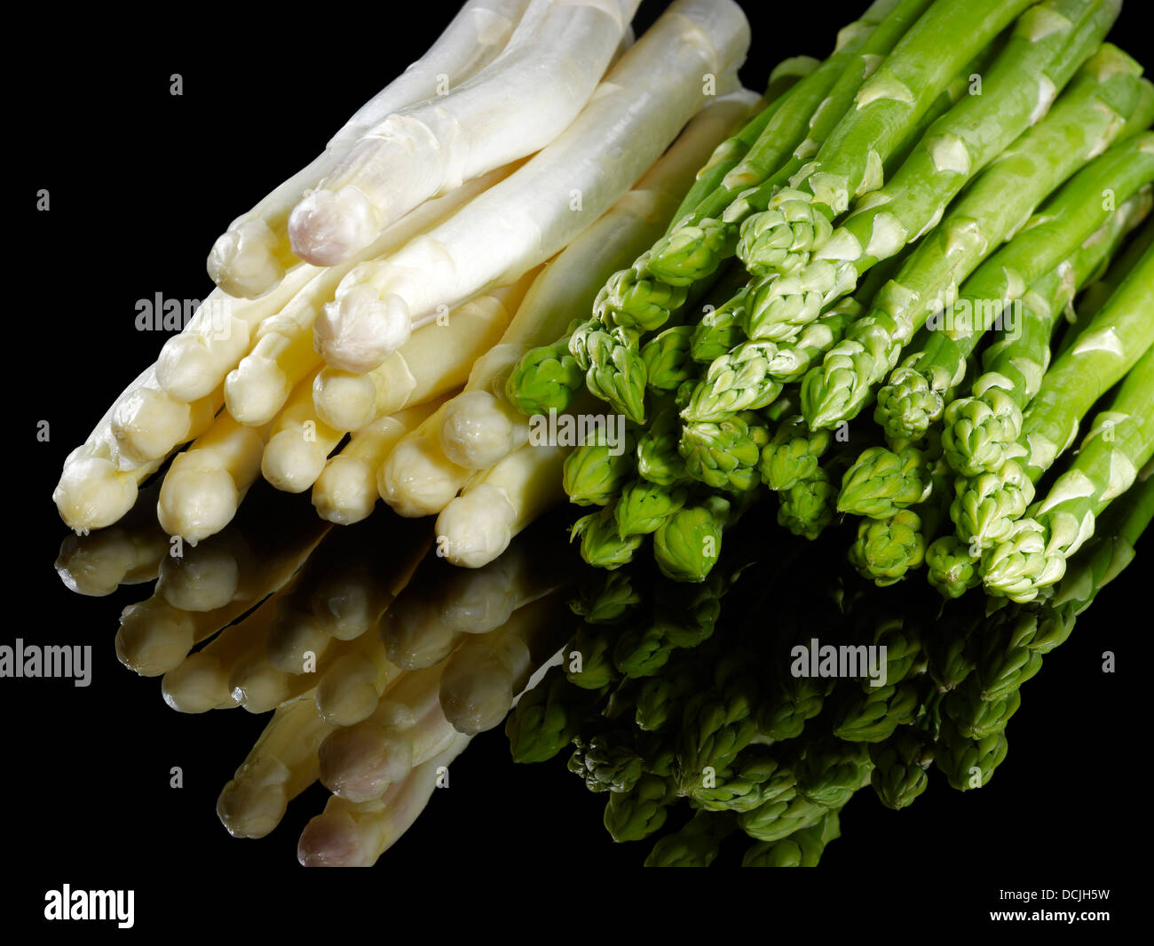 Trauben von weißem und grünem Spargel Gemüse in Schwarz Reflektierende Rückseite Stockfoto