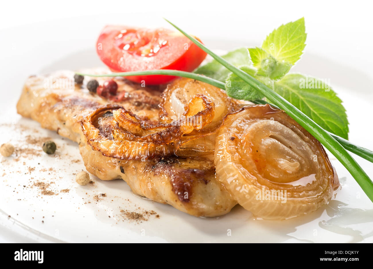 Schweinesteak mit Tomaten und gebratenen Zwiebeln Stockfoto