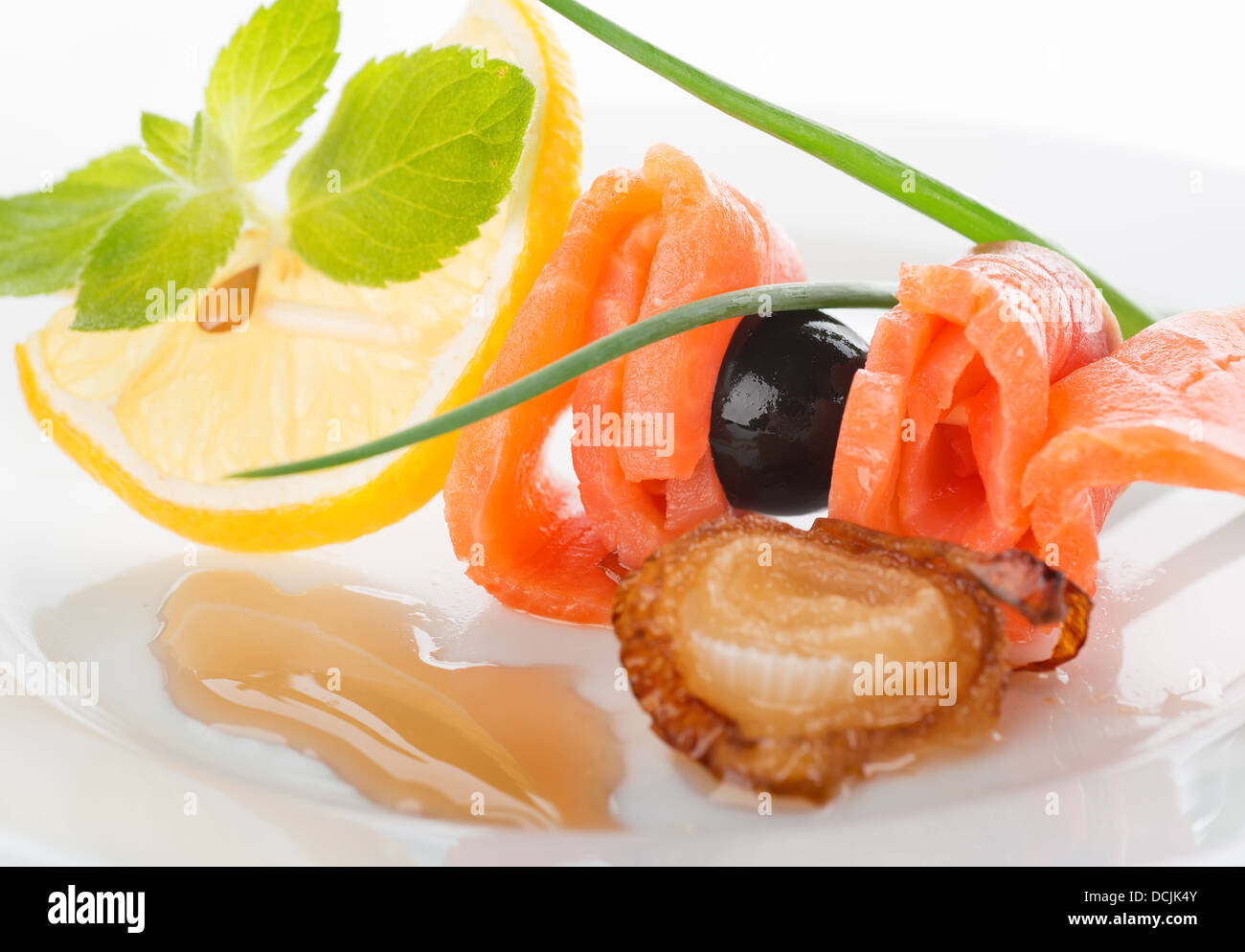 Rollen von roter Fisch mit Zitrone und gebratenen Zwiebeln Stockfoto