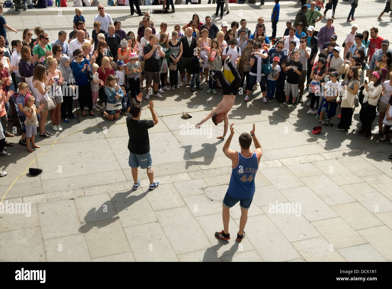 Touristen Trafalgar Square beobachten Straßenakrobaten auftreten. London UK 2013 2010er HOMER SYKES Stockfoto