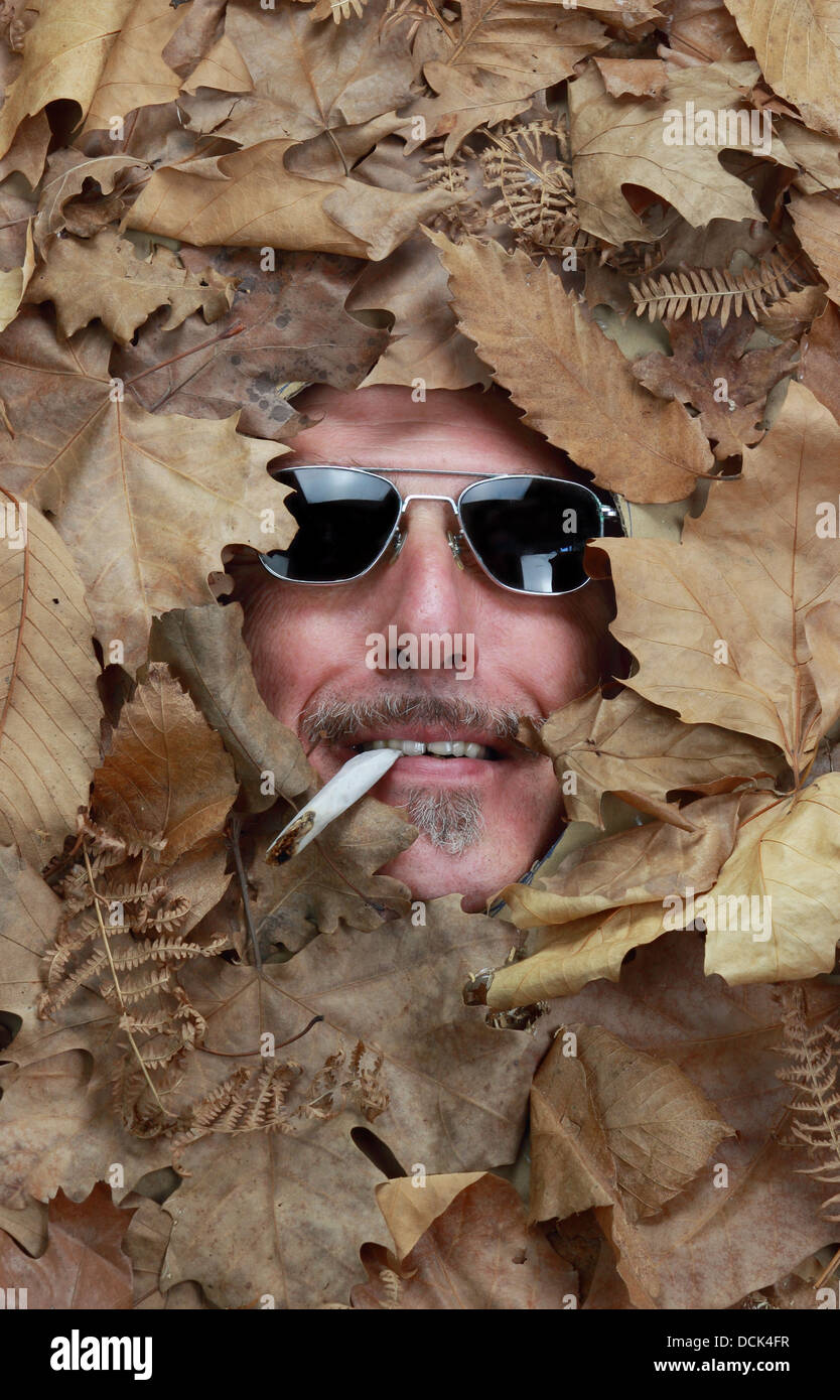 lächelnd Mann mit Zigarette unter einem Bett fallen lässt Stockfoto