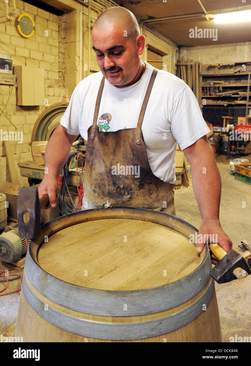 Meister Cooper Denis Merten setzt eine Ringon ein Fass auf Cooperage Messerschmidt in Neu Zittau, Deutschland, 29. Juli 2013. Foto: Bernd Settnik Stockfoto