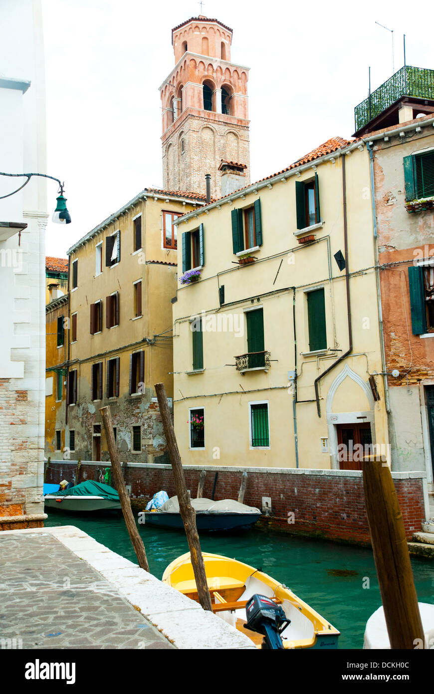 Einen kleinen Kanal in Venedig, Italien, mit gelben festgemachten Boot und traditionellen venezianischen Gebäuden. Stockfoto