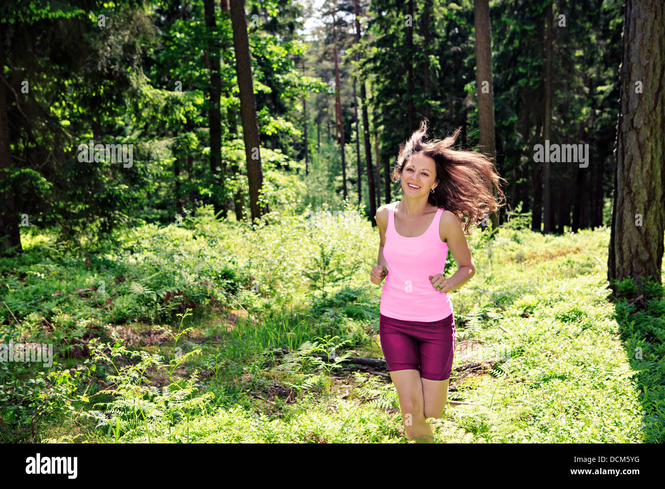 junge Frau im Wald joggen Stockfoto