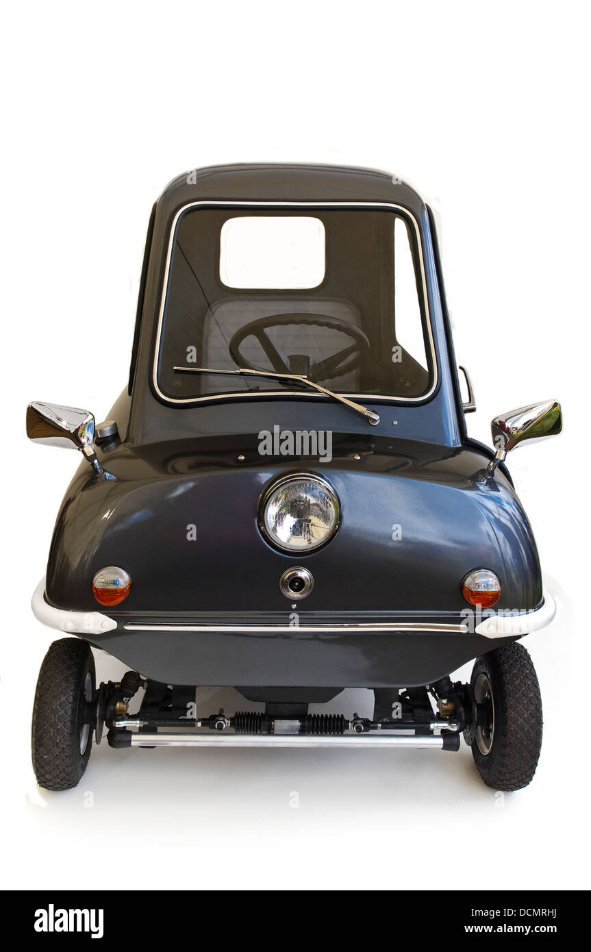 Vertikale Nahaufnahme eines winzigen Peel P50 Autos vor einem weißen Hintergrund. Stockfoto