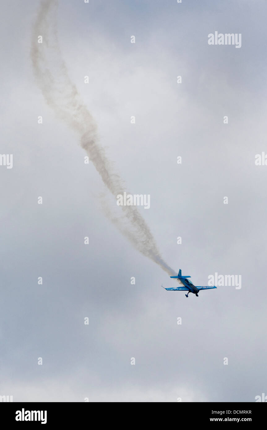 Vertikale Ansicht eines Flugzeugs mit einem Dampf-Trail tun Stunts während einer Flugschau. Stockfoto