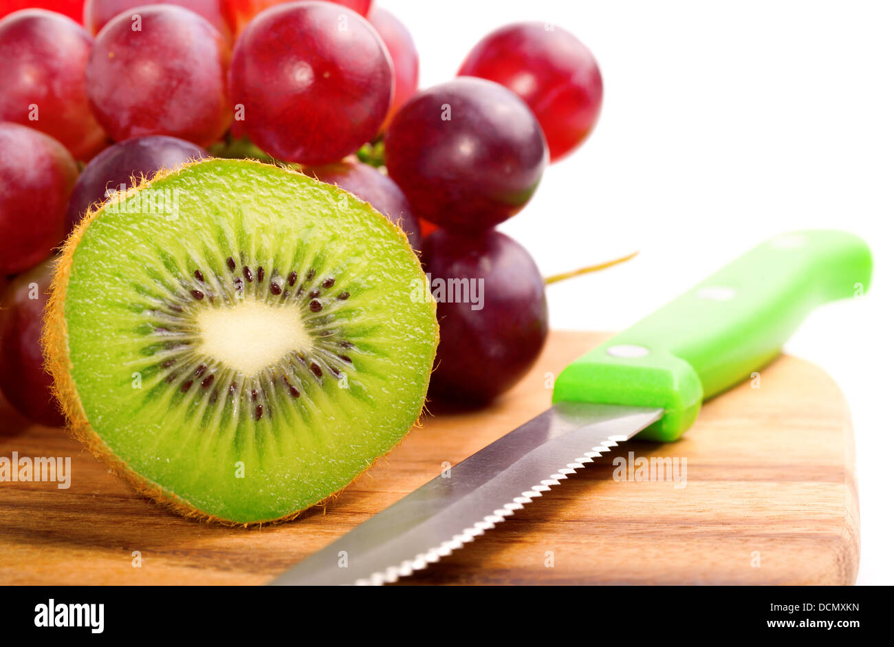 Einzelnen Querschnitts von Kiwi auf Trauben Hintergrund auf weiß Stockfoto