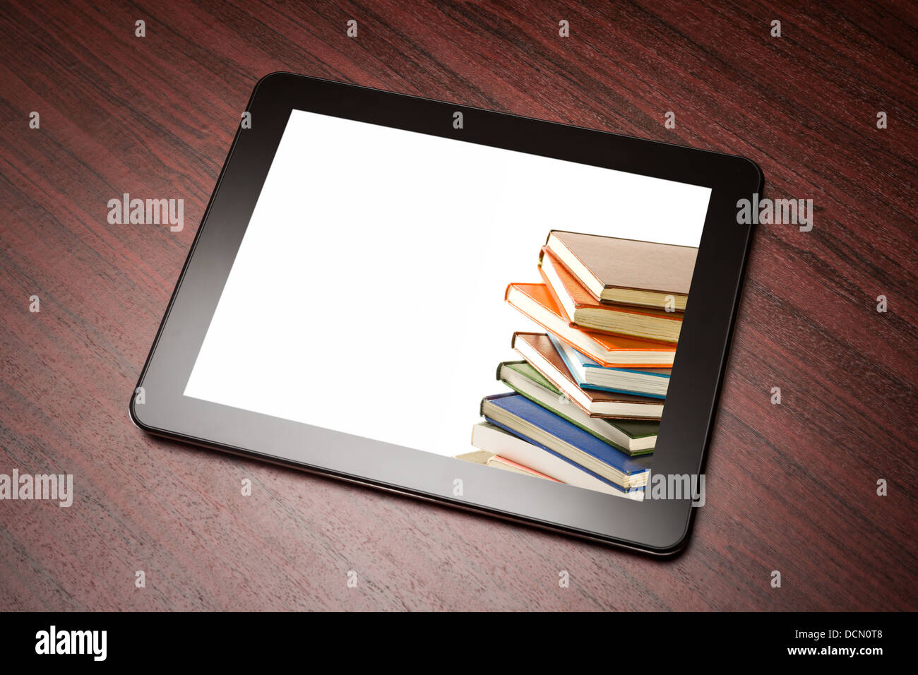 Tablet mit Buch auf dem Tisch. Stockfoto