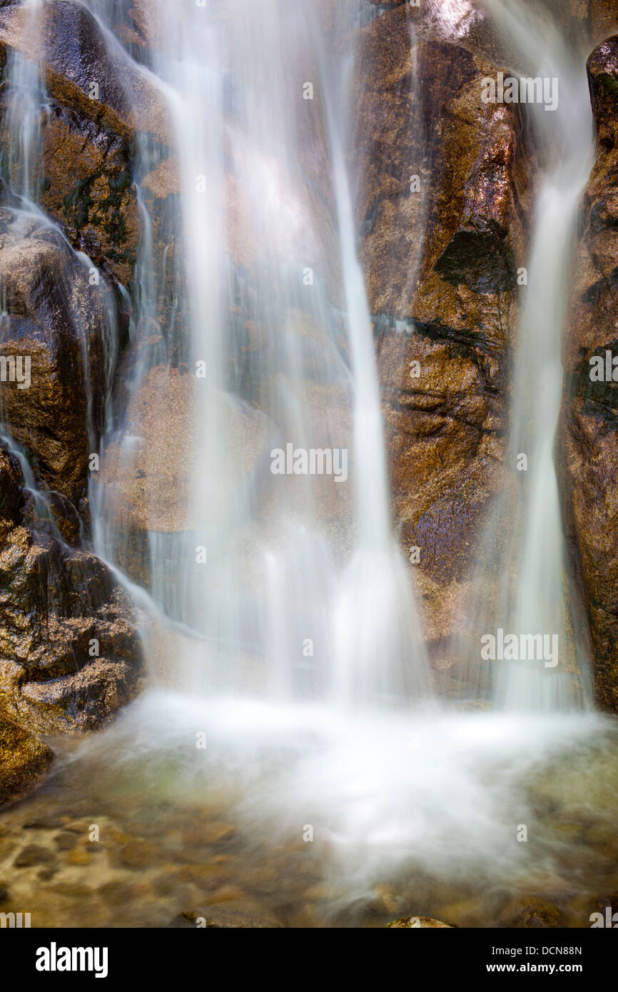 Nahaufnahme eines Wasserfalls und glitzernde Steinen mit langer Belichtungszeit verwischen. Stockfoto