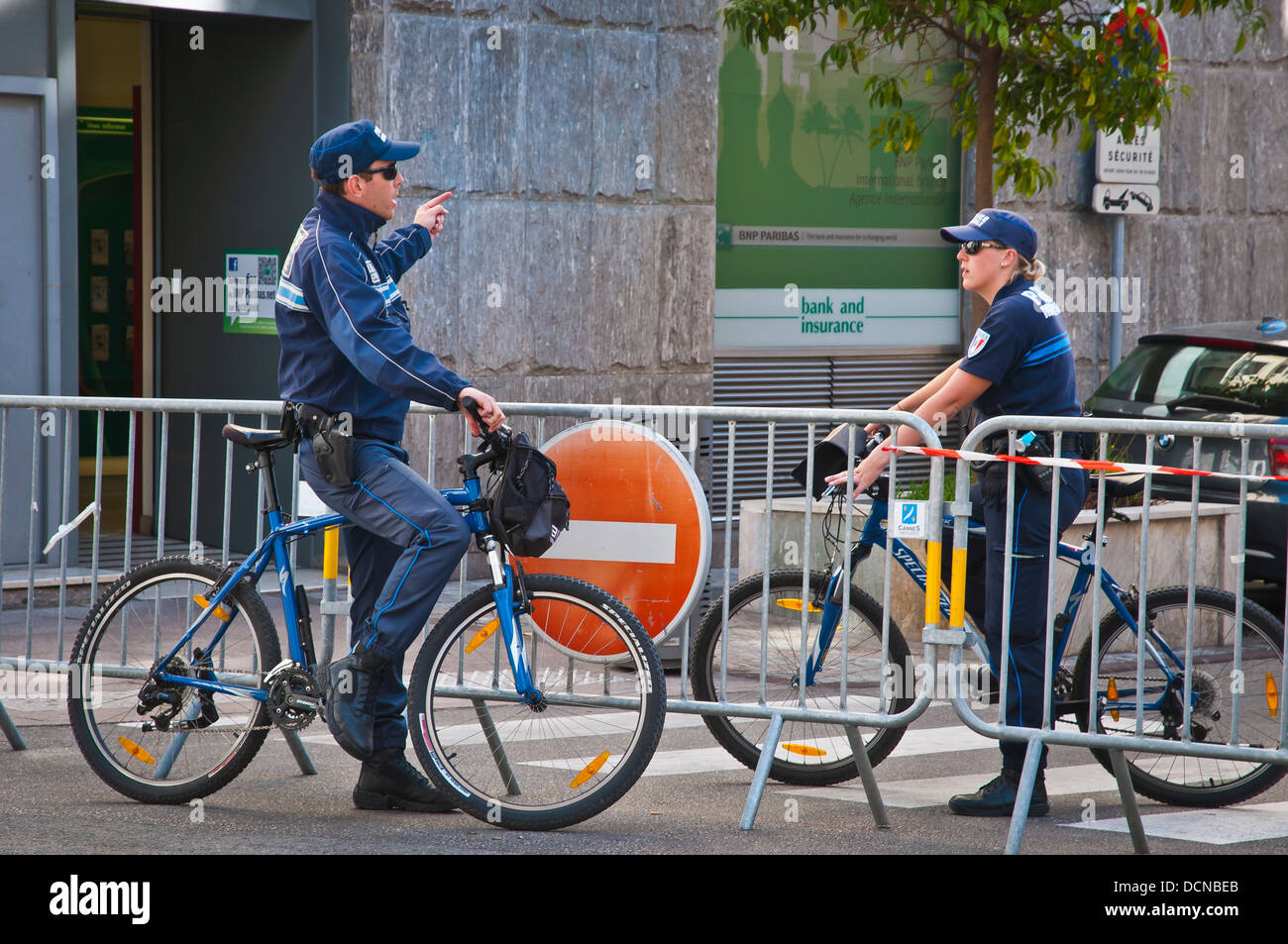 Eine Straßenszene mit zwei Polizisten Gespräche, Cannes, Côte d ' Azur, Frankreich. Stockfoto