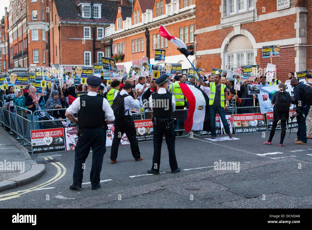 London, 20.08.2013. Polizei zusehen, wie Demonstranten schreien und vor der ägyptischen Botschaft im Zuge der anhaltenden Proteste gegen die militärische Übernahme des gestürzten Präsidenten Morsi demokratisch gewählte Regierung singen. Stockfoto