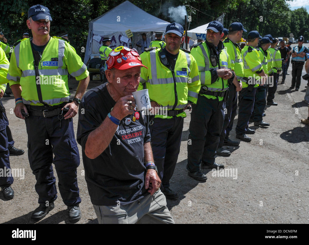 Rentner haben etwas besseres verdient. 79 Jahre alte Terry Hutt genießt eine Gebräu vor der Polizeiabsperrung Cuadrillas Website Eingang in Balcombe, West Sussex, Großbritannien Stockfoto