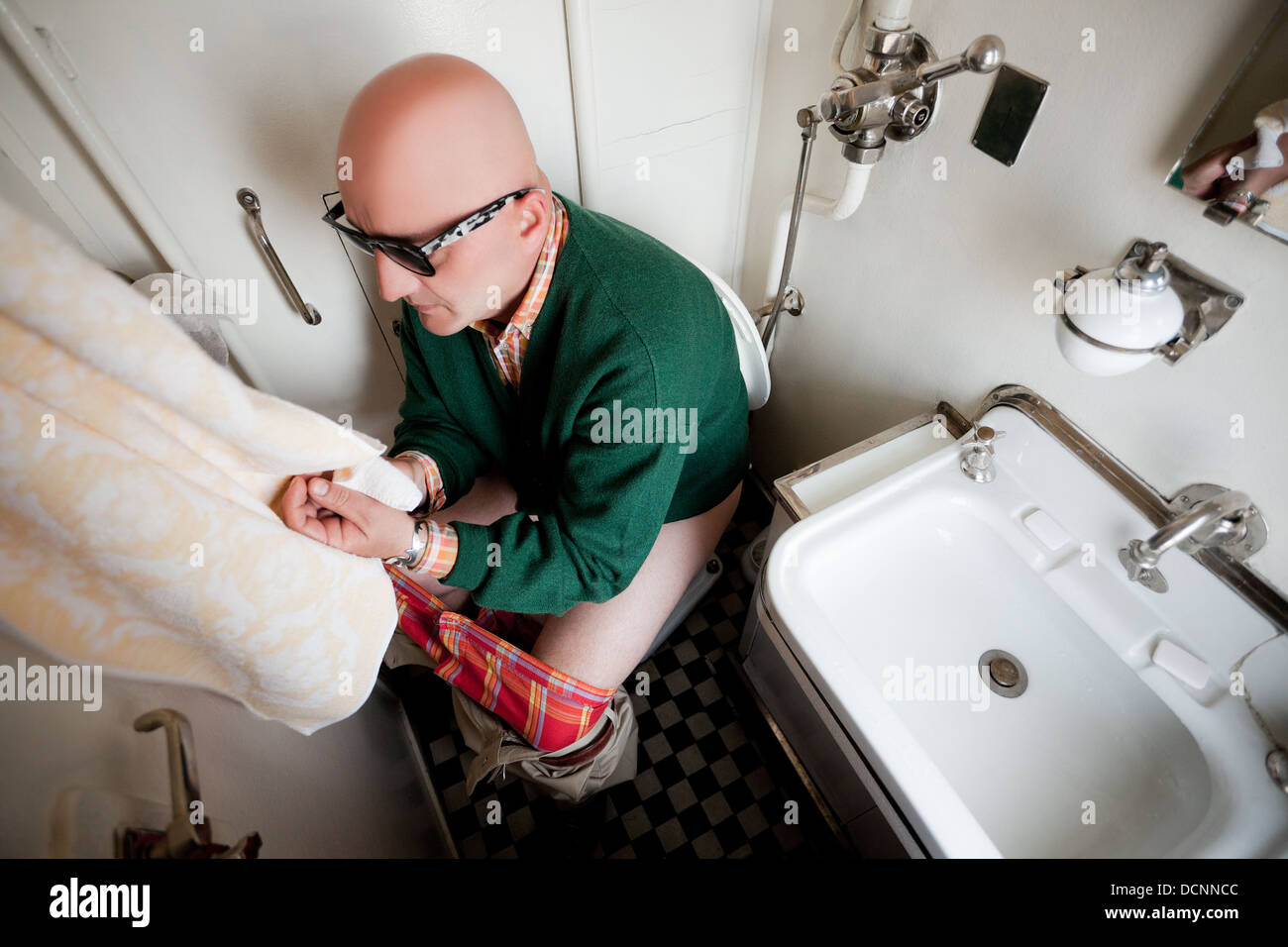 Mann sitzt auf einer Toilette im Zug Stockfoto