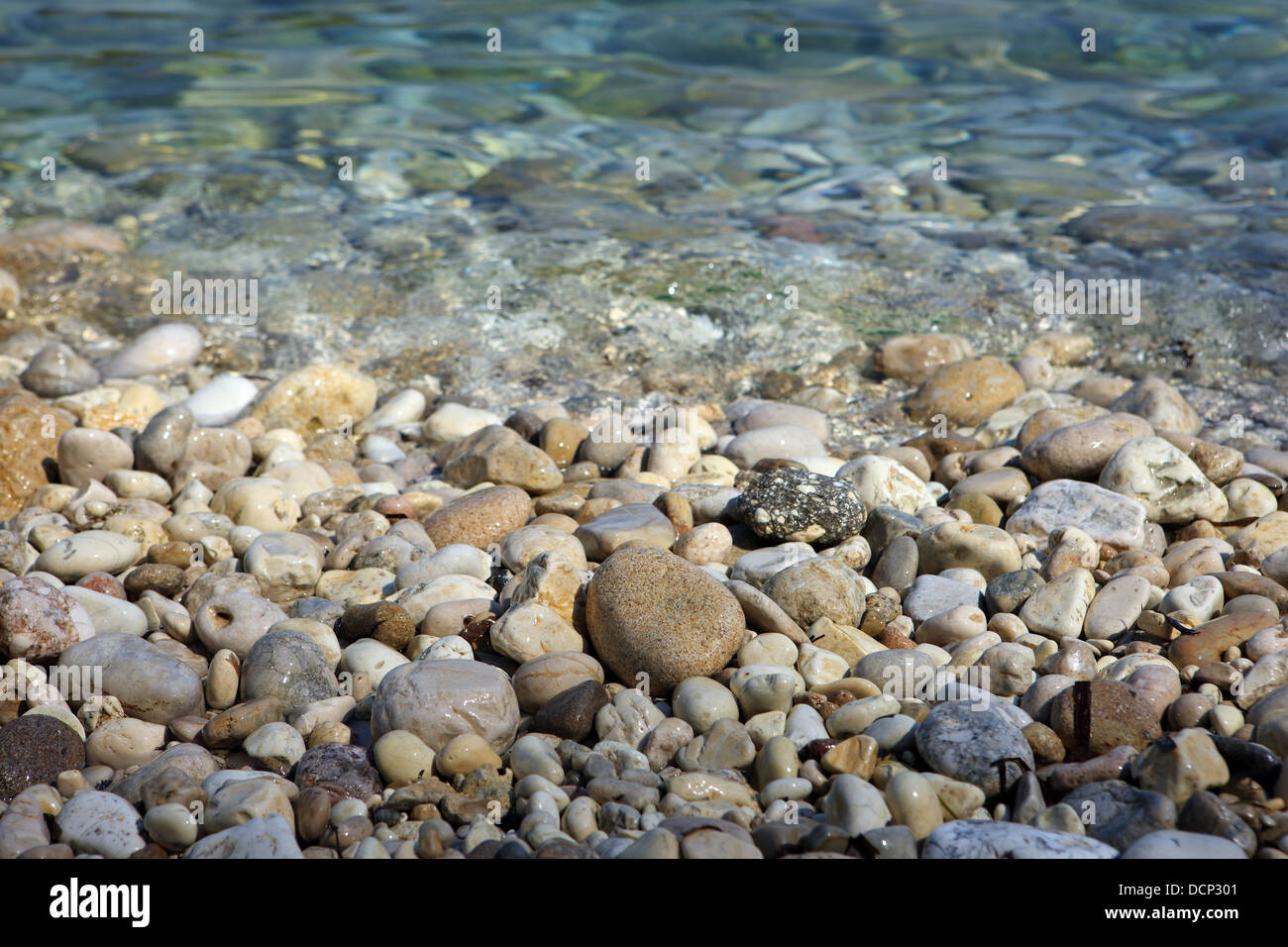 Kieselsteine am Rand des Wassers am griechischen Strand Stockfoto