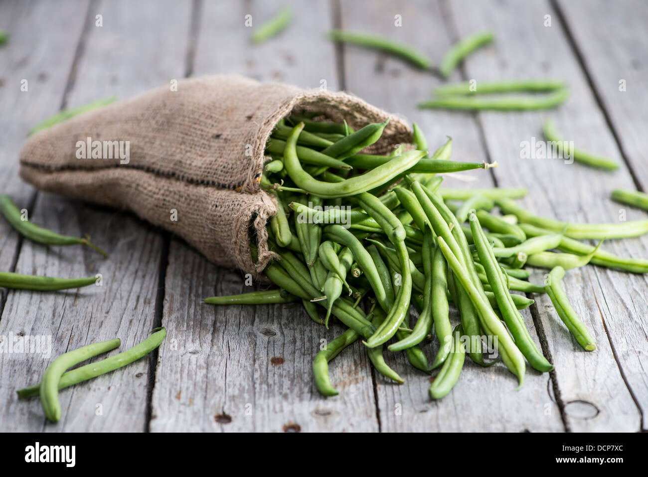 Einige grüne Bohnen auf hölzernen Hintergrund Stockfoto