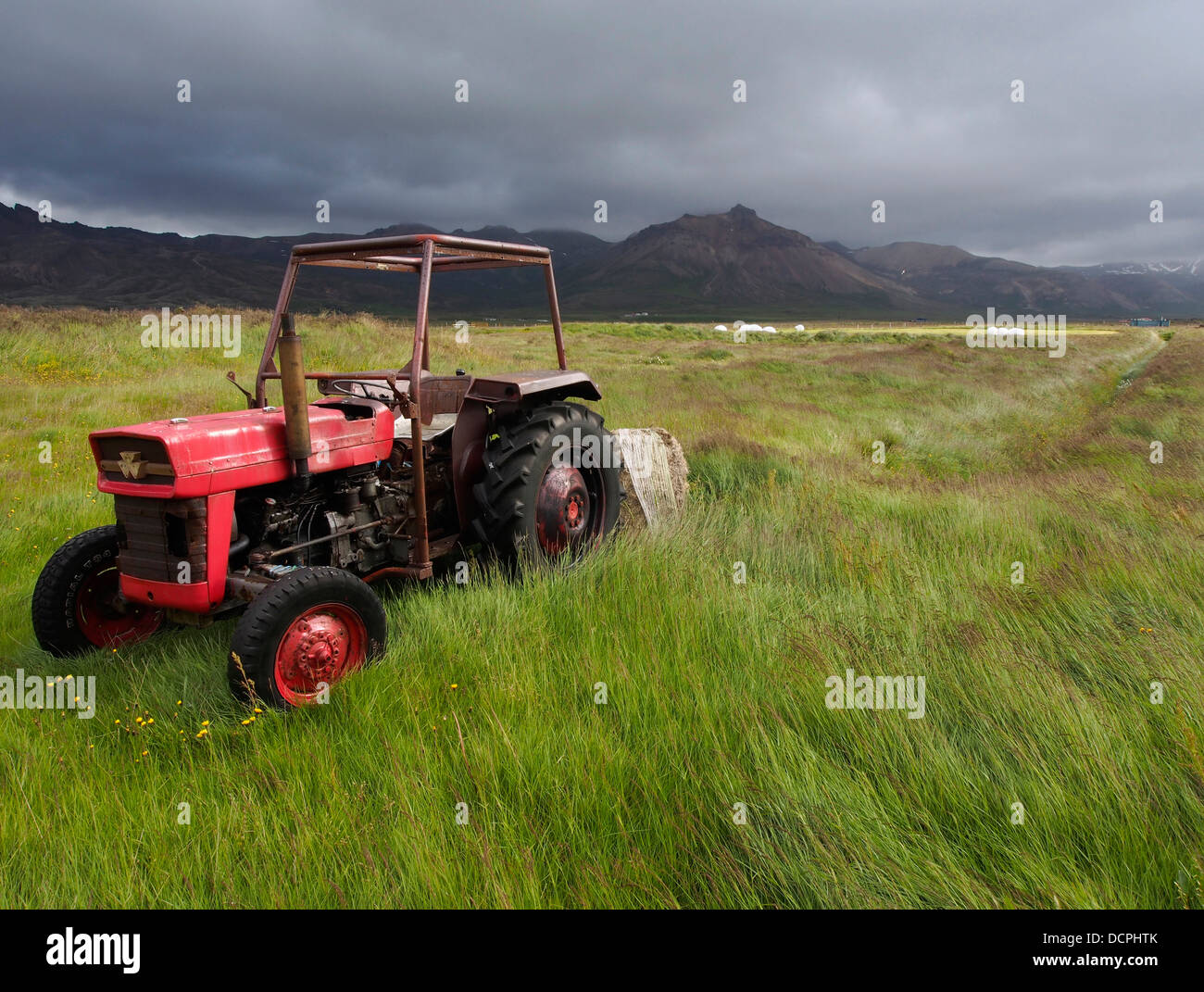 Roter Traktor, Bakkagerði, Berggipfeln Eystri, Island Stockfoto