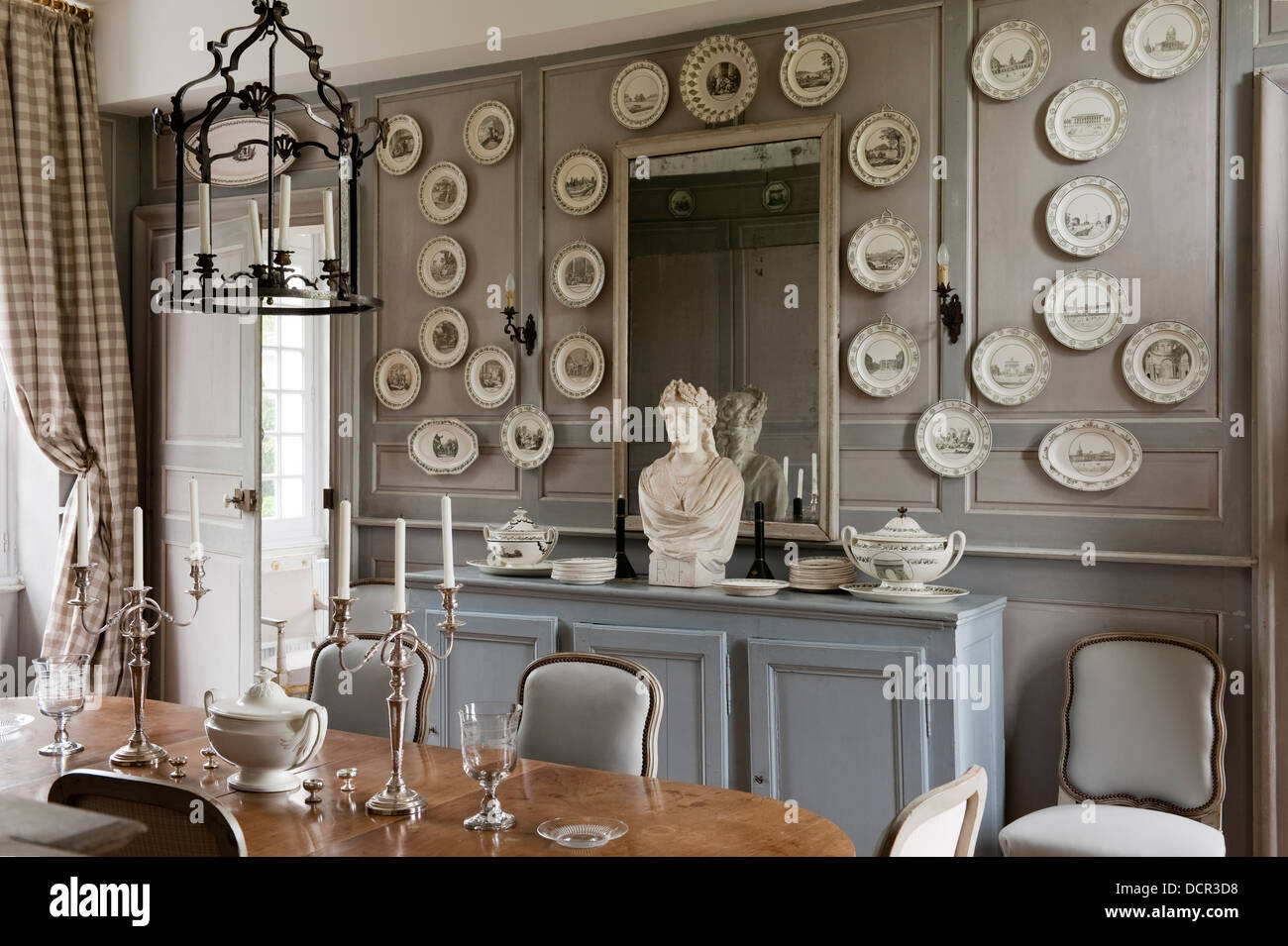 Französisch antike Stühle und Tisch im eleganten Speisesaal mit hölzernen  Wandverkleidung und dekorativer Porzellanteller Stockfotografie - Alamy