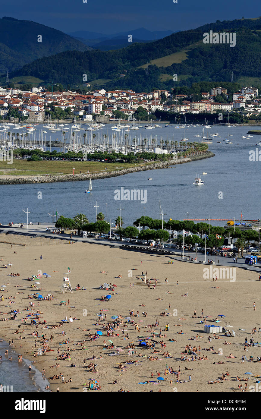 Sommer auf überfüllten Hondarribia Strand in Nordspanien mit der Mündung des Flusses Bidasoa und Hendaye Beach in Frankreich im Hintergrund Stockfoto