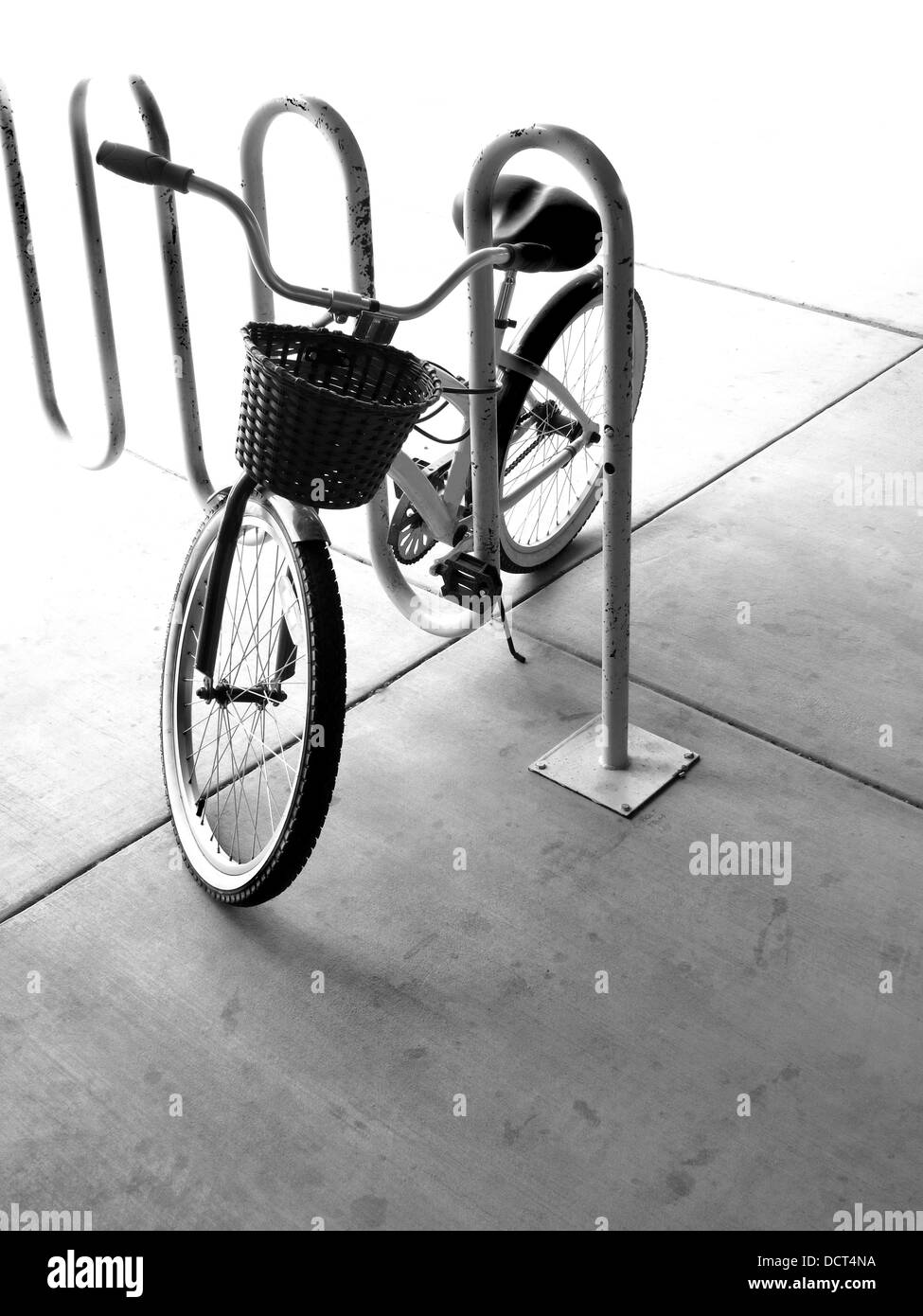 Ein einzelnes Fahrrad mit Korb in einem Fahrradständer in der Stadt Stockfoto