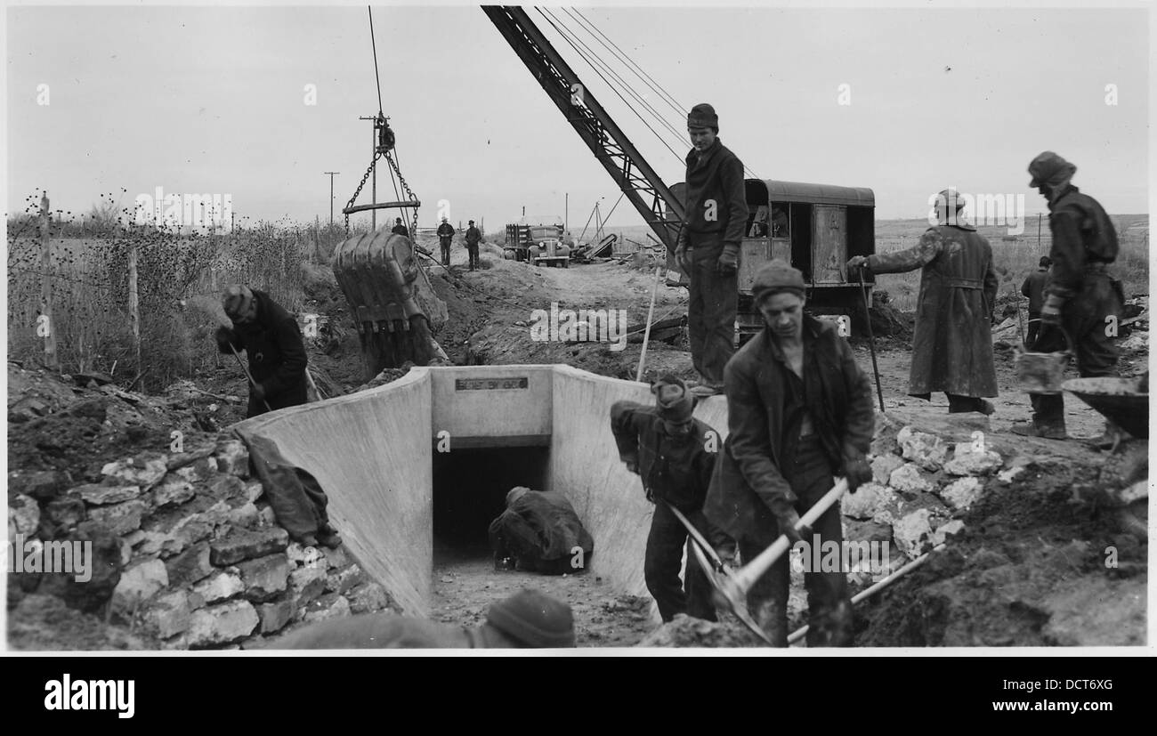 Diese Abbildung zeigt die Hinterfüllung von Betonbauwerken in CCC Camp BR-23 und 71-372 im Rahmen des Uncompahgre-Projekts in Montrose, Colorado. Das Foto zeigt die Bauarbeiten, die während des New Deal-Zeitalters durchgeführt wurden. Stockfoto Diese Abbildung zeigt die Hinterfüllung von Betonbauwerken in CCC Camp BR-23 und 71-372 im Rahmen des Uncompahgre-Projekts in Montrose, Colorado. Das Foto zeigt die Bauarbeiten, die während des New Deal-Zeitalters durchgeführt wurden. Stockfoto