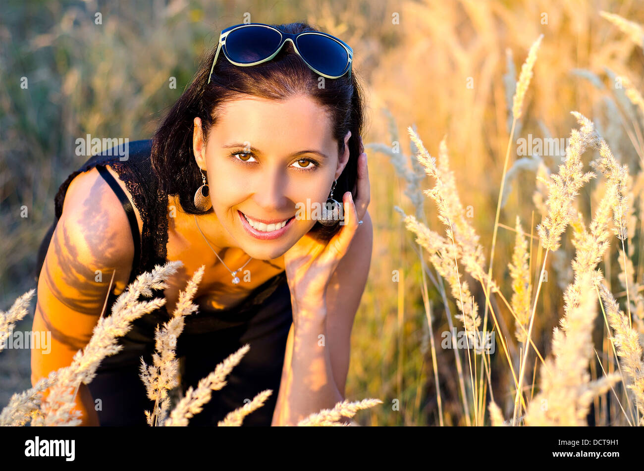 Junge Frau in den Rasen im Sommer Stockfoto