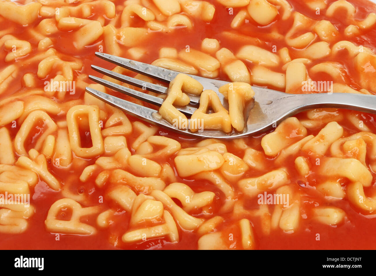 Gabel mit Alphabet Spaghetti Schreibweise auf einem Hintergrund von gemischten Alphabet Spaghetti Essen Stockfoto