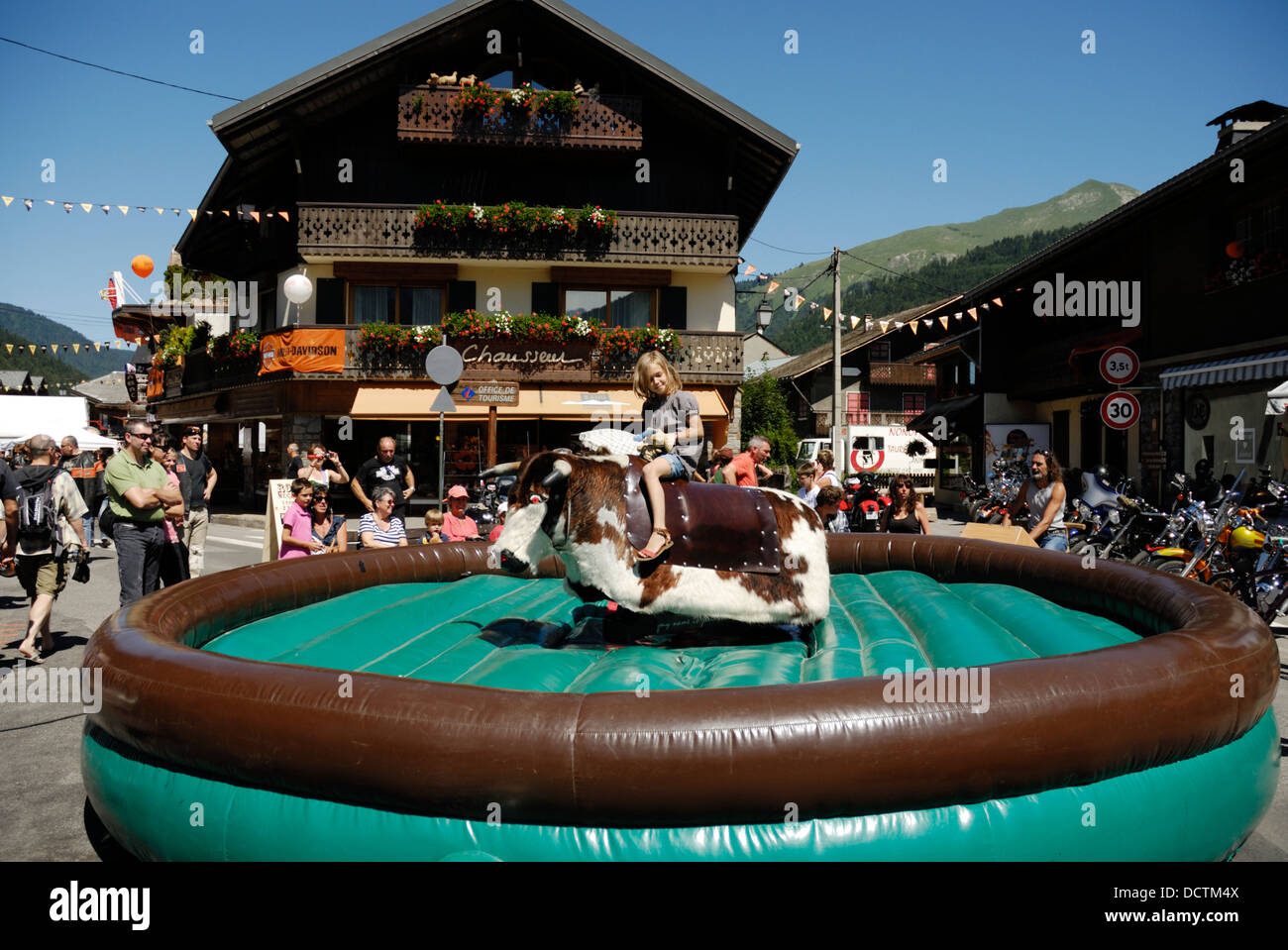 Junge Mädchen reitet mechanischen Bullen, Morzine Harley Days Festival 2011 Stockfoto