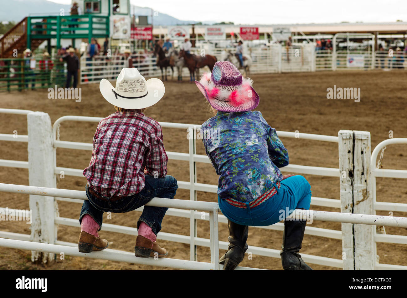 Junge & Mädchen gehockt Corral Zaun beobachten das Chaffee County Rodeo Stockfoto