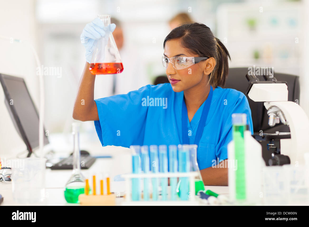 schöne junge indische Mediziner analysieren Flüssigkeit in eine Flasche Stockfoto