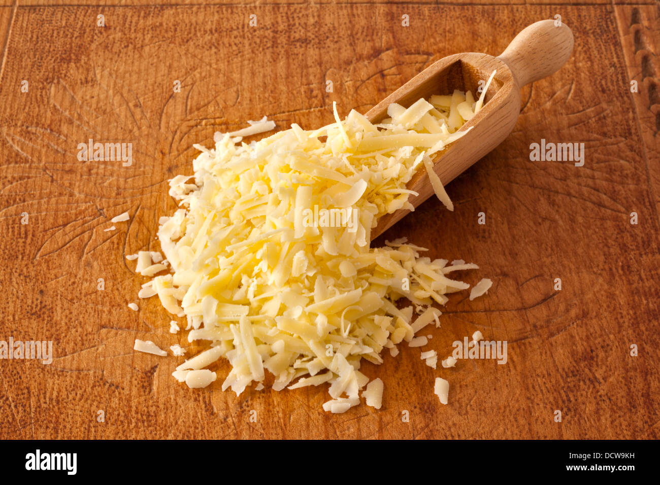 Geriebenem Käse - eine Kugel geriebenen Cheddar-Käse auf einem alten Holzbrett. Stockfoto